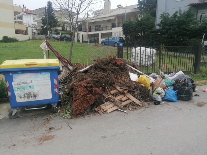 Κλαδιά και ογκώδη αντικείμενα παρατημένα δίπλα σε κάδους απορριμμάτων σε δρόμο του Δήμου Θέρμης
